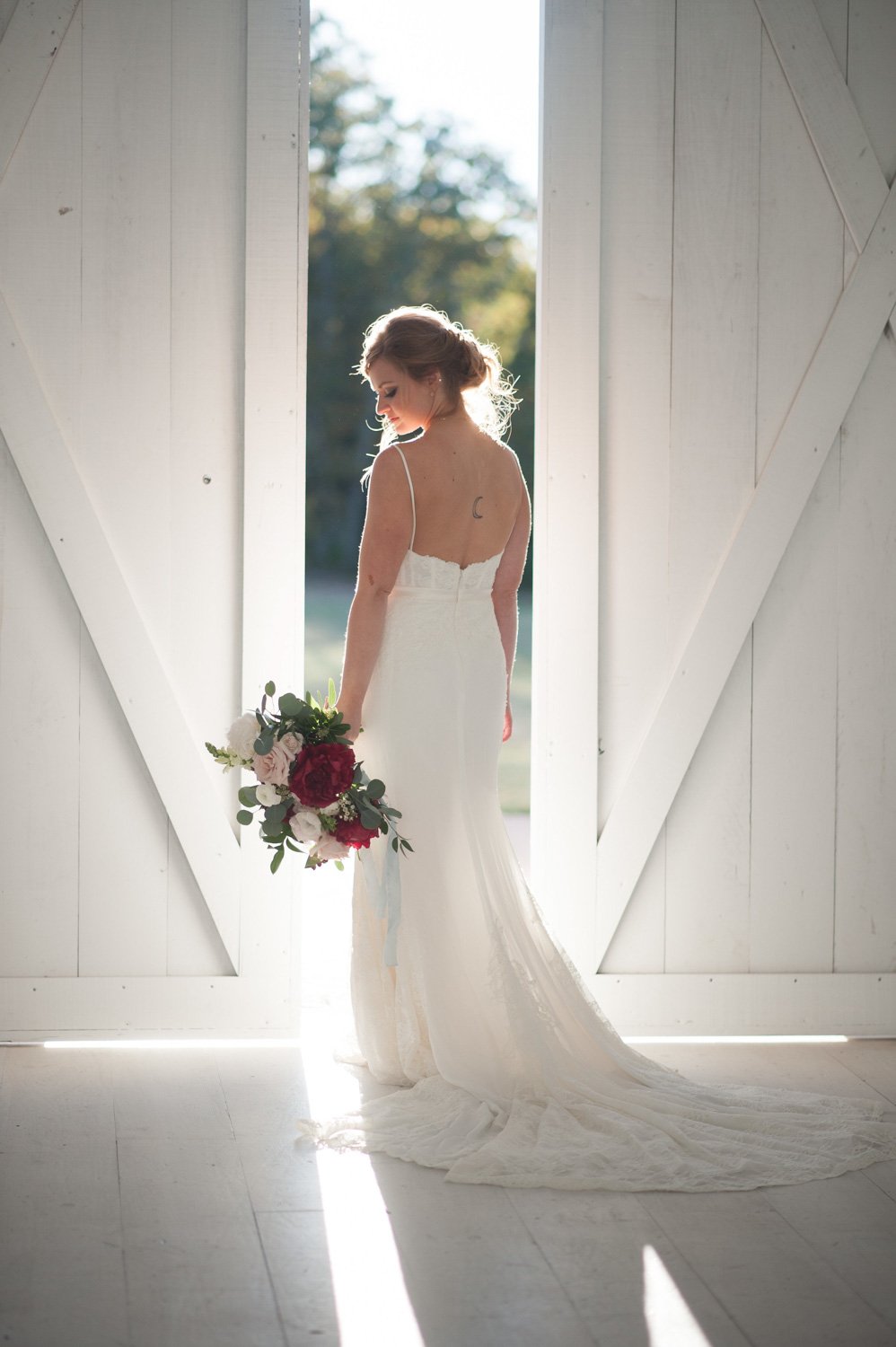 Bride in front of white barn door